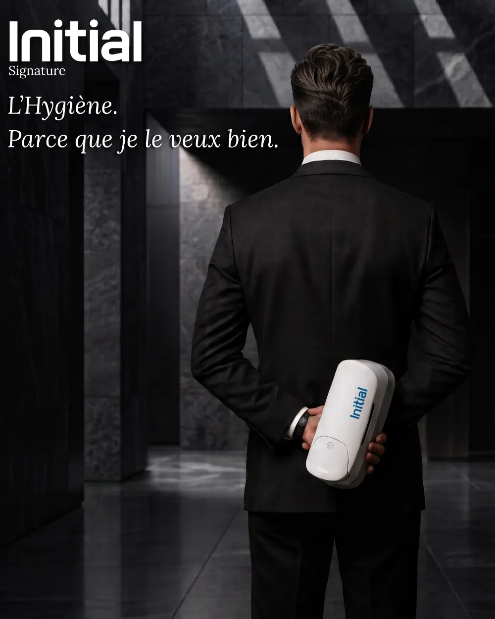 Distributeur d'hygiène de luxe Initial Signature, campagne créée par Kévin Vigreux — homme en costume, dans un hall marbré